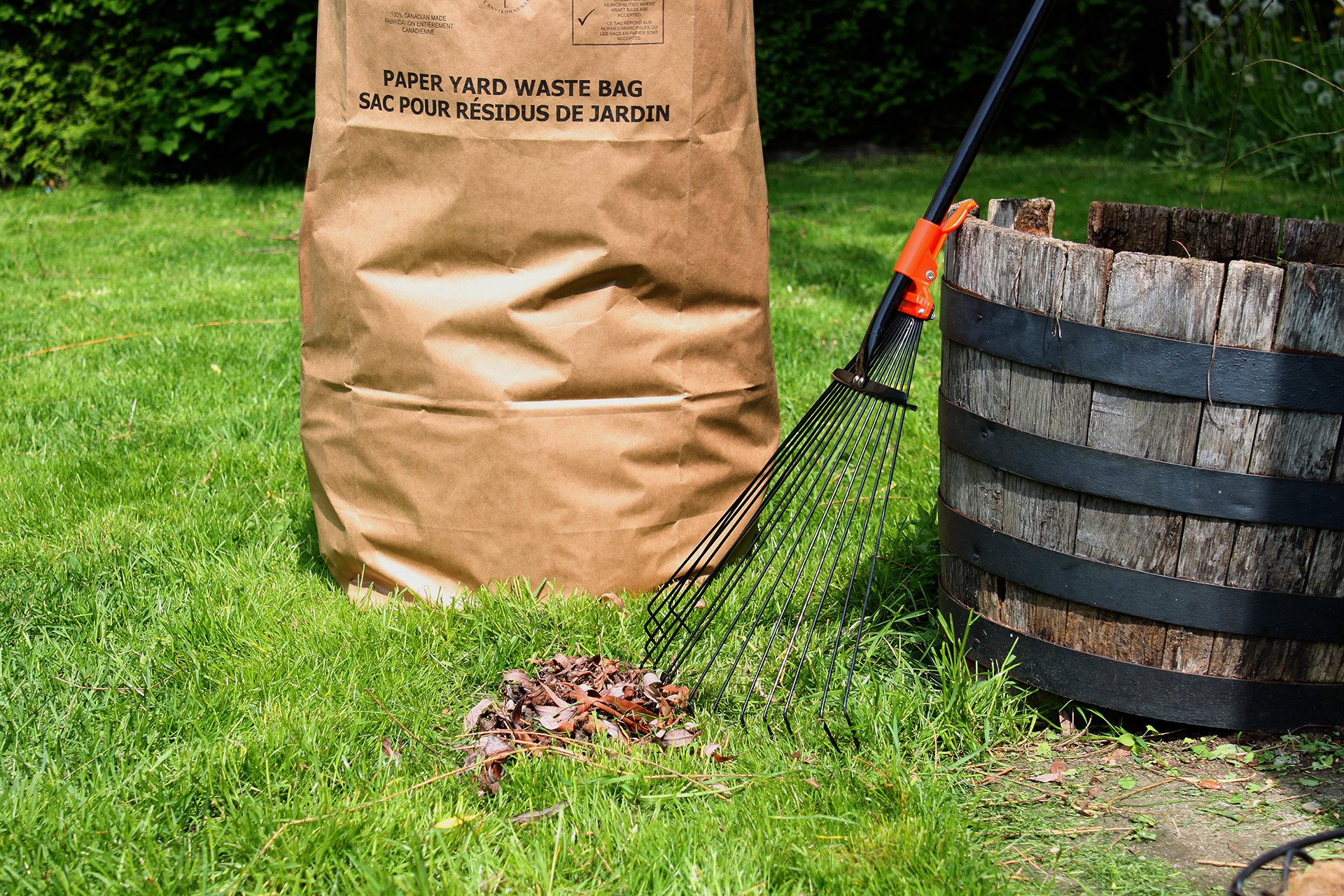 240 litre green bin liner filled with yard leaves near rake