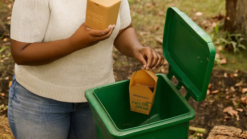 Woman disposing of loaded Grease Buddy liner into compost bin